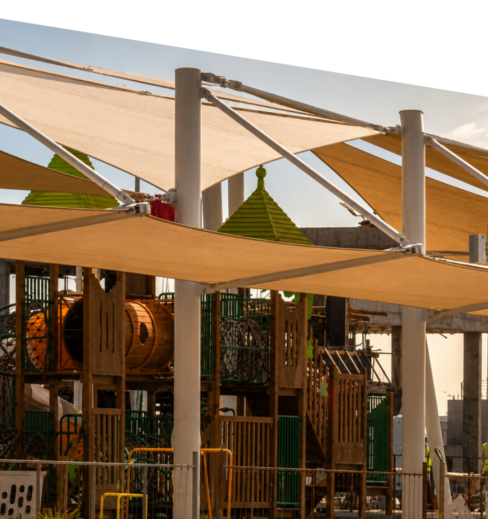 Landscaped entertainment area with shade sails and playground structures